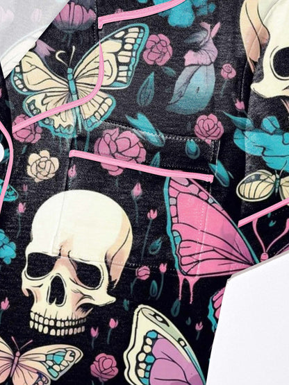 Black modal pajama set with cream skulls, pink and turquoise butterflies and floral accents — short sleeve button top and elastic waist shorts with piping