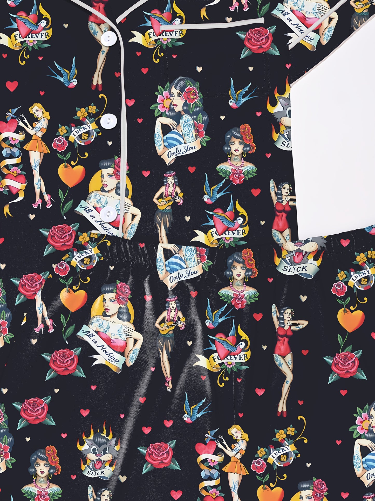 Black silk‑touch modal pajama set with colorful tattoo‑flash print — short‑sleeve button top and elastic waist shorts with white piping