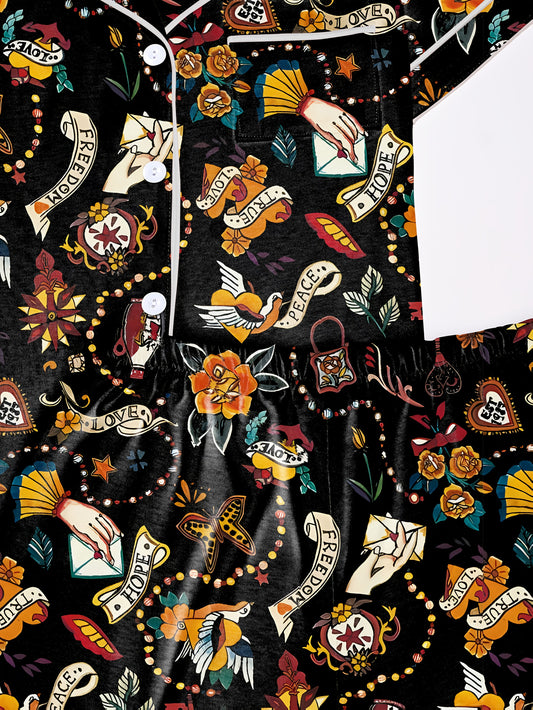 Navy/black modal pajama set with vintage tattoo‑style roses, doves and script banners — short‑sleeve button top and elastic waist shorts with piping