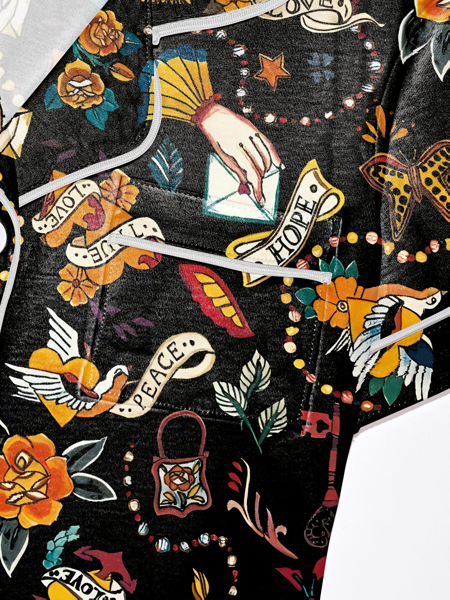 Navy/black modal pajama set with vintage tattoo‑style roses, doves and script banners — short‑sleeve button top and elastic waist shorts with piping