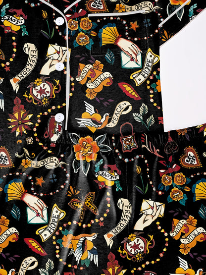 Navy/black modal pajama set with vintage tattoo‑style roses, doves and script banners — short‑sleeve button top and elastic waist shorts with piping