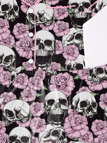 Black modal pajama set with white skulls and pink roses — short‑sleeve button top and elastic waist shorts with pale contrast piping
