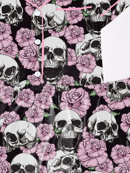 Black modal pajama set with white skulls and pink roses — short‑sleeve button top and elastic waist shorts with pale contrast piping