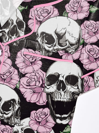 Black modal pajama set with white skulls and pink roses — short‑sleeve button top and elastic waist shorts with pale contrast piping