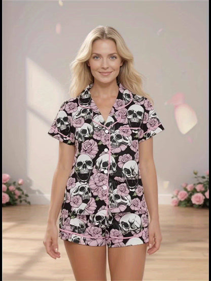 Black modal pajama set with white skulls and pink roses — short‑sleeve button top and elastic waist shorts with pale contrast piping