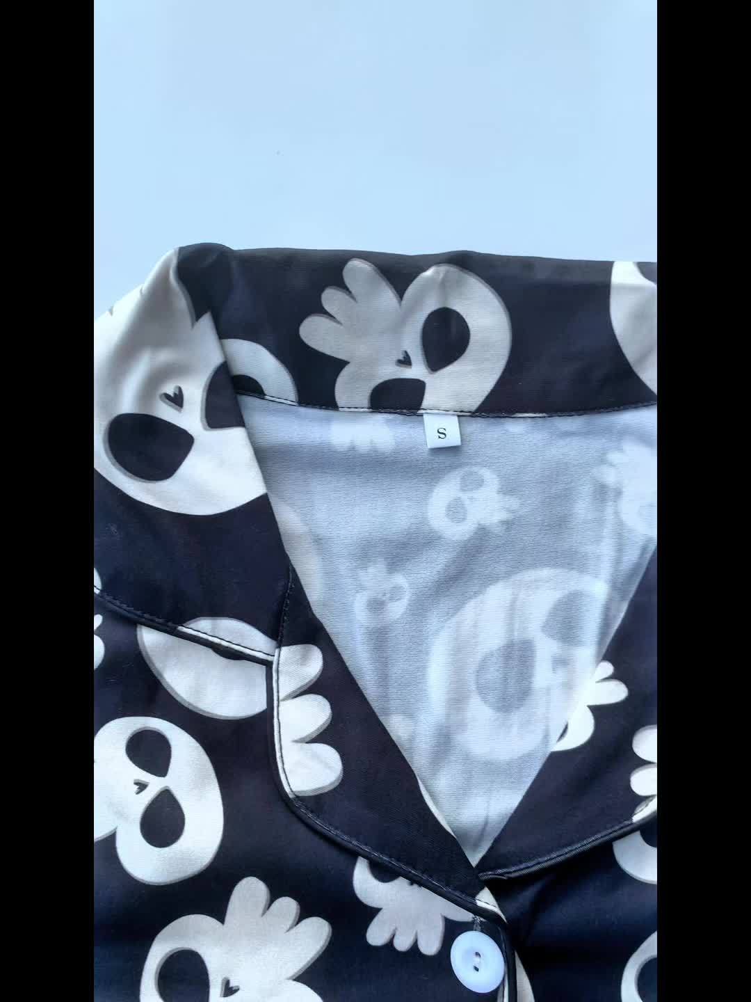 Black modal pajama set with cream skull motifs — short‑sleeve button top and elastic waist shorts with piping