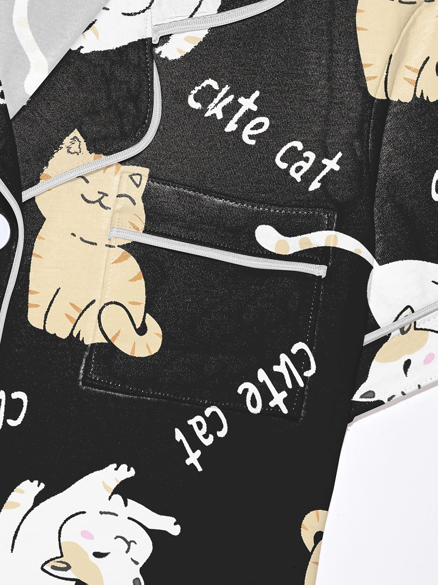 Black modal short‑sleeve pajama set with cream and tan cat print — button top with notch collar and elastic waist shorts with gray piping