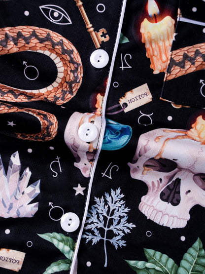 Black modal pajama set with skulls, snake and crystal print — short‑sleeve button top and elastic waist shorts with pale piping