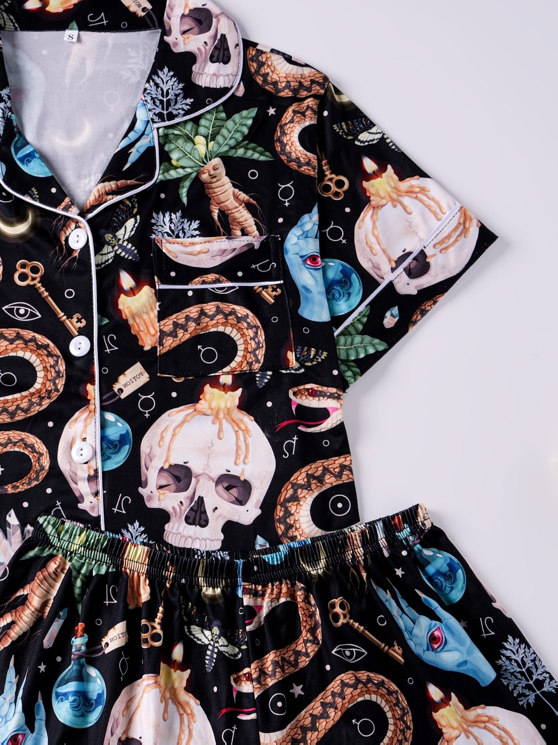 Black modal pajama set with skulls, snake and crystal print — short‑sleeve button top and elastic waist shorts with pale piping