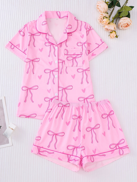 Pink satin-look short sleeve pajama set with bow print and hearts, piped trim, chest pocket and elastic waist shorts in 95% Polyester 5% Elastane — silky stretch loungewear