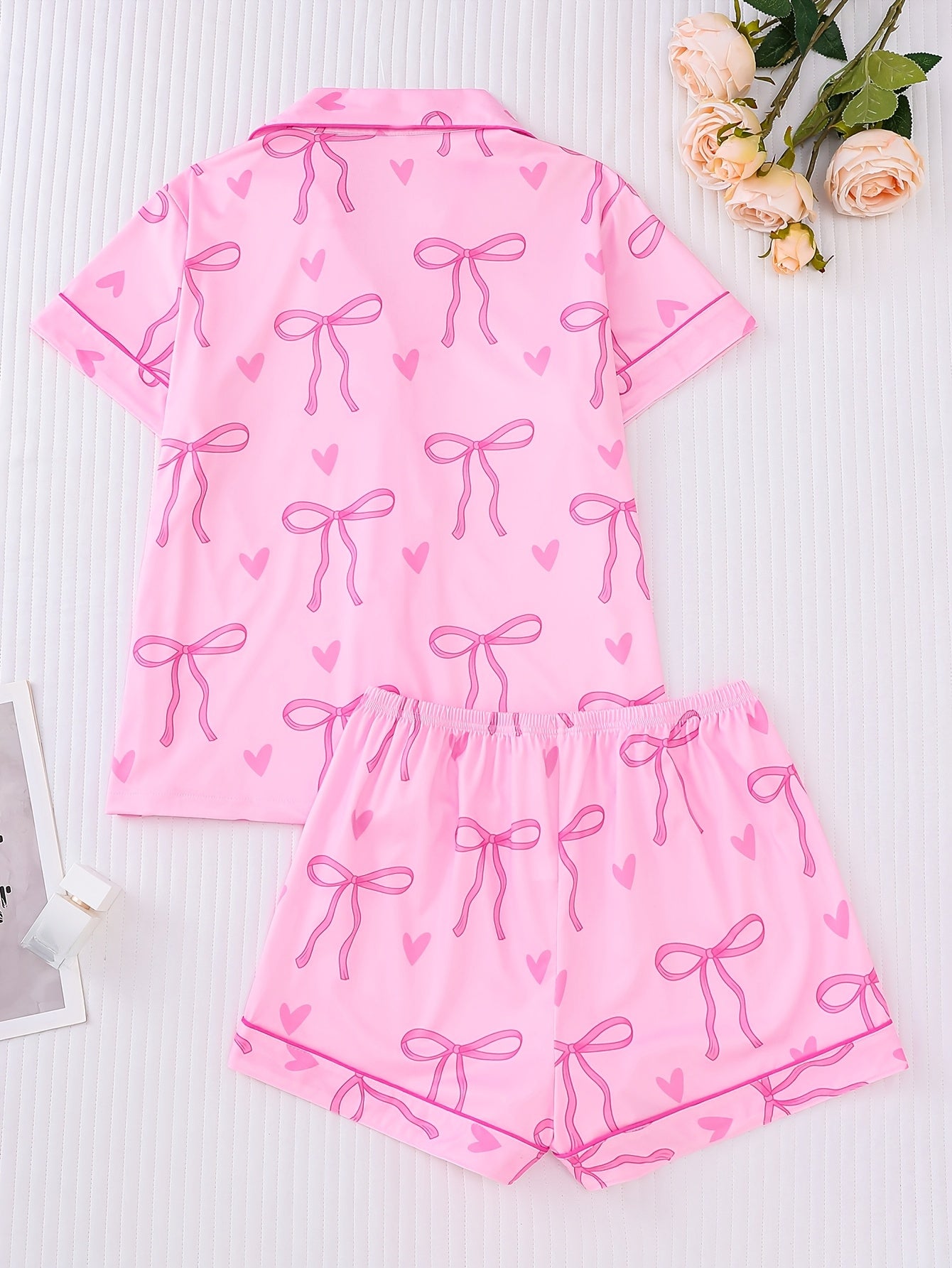 Pink satin-look short sleeve pajama set with bow print and hearts, piped trim, chest pocket and elastic waist shorts in 95% Polyester 5% Elastane — silky stretch loungewear