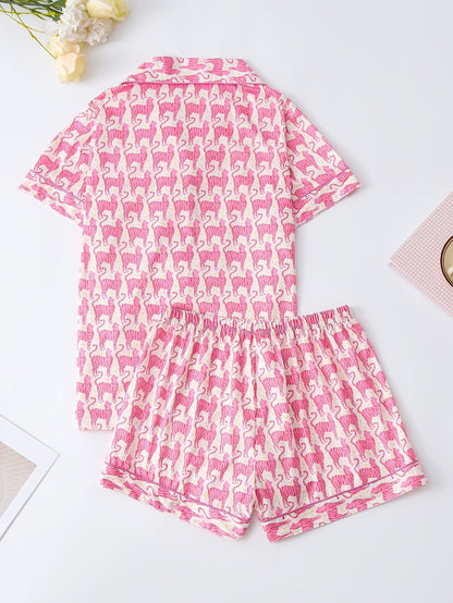 Pink satin-look short-sleeve pajama set with repeating zebra print, piped trim and elastic waist shorts in 95% Polyester 5% Elastane — silky stretch travel-ready loungewear