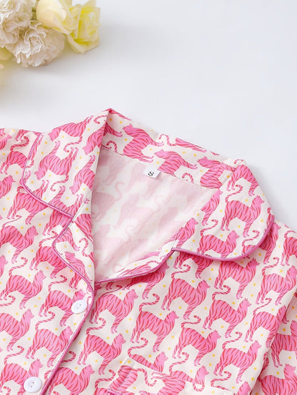 Pink satin-look short-sleeve pajama set with repeating zebra print, piped trim and elastic waist shorts in 95% Polyester 5% Elastane — silky stretch travel-ready loungewear