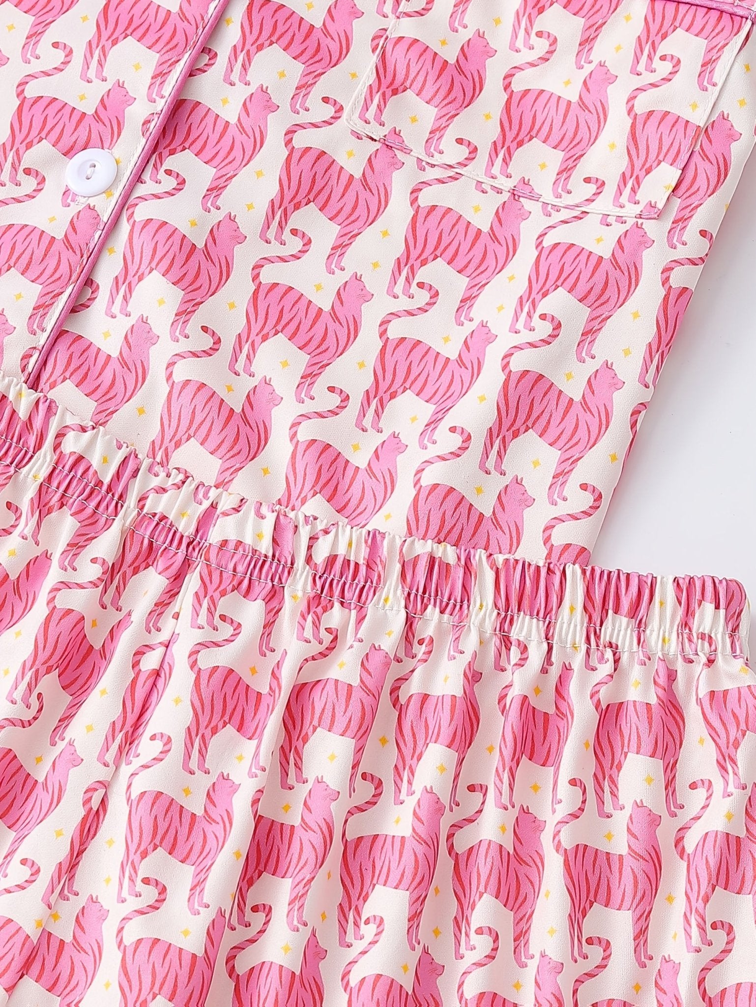 Pink satin-look short-sleeve pajama set with repeating zebra print, piped trim and elastic waist shorts in 95% Polyester 5% Elastane — silky stretch travel-ready loungewear