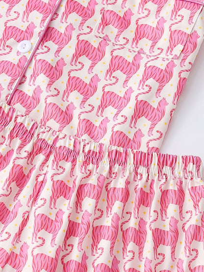 Pink satin-look short-sleeve pajama set with repeating zebra print, piped trim and elastic waist shorts in 95% Polyester 5% Elastane — silky stretch travel-ready loungewear