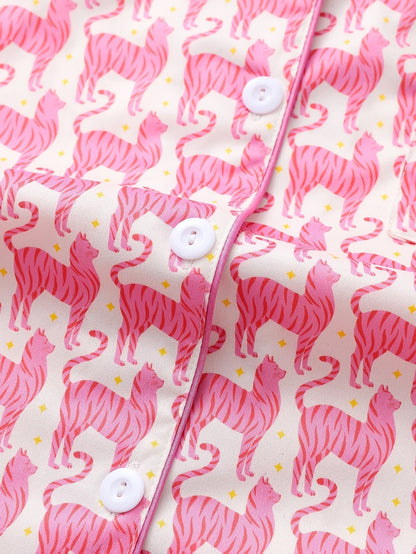 Pink satin-look short-sleeve pajama set with repeating zebra print, piped trim and elastic waist shorts in 95% Polyester 5% Elastane — silky stretch travel-ready loungewear