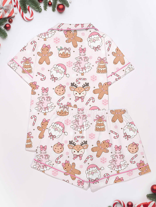 Back view of pastel pink women’s short-sleeve pajama set with gingerbread, Santa and candy cane print — button-up top and elastic waist shorts in 95% polyester 5% elastane