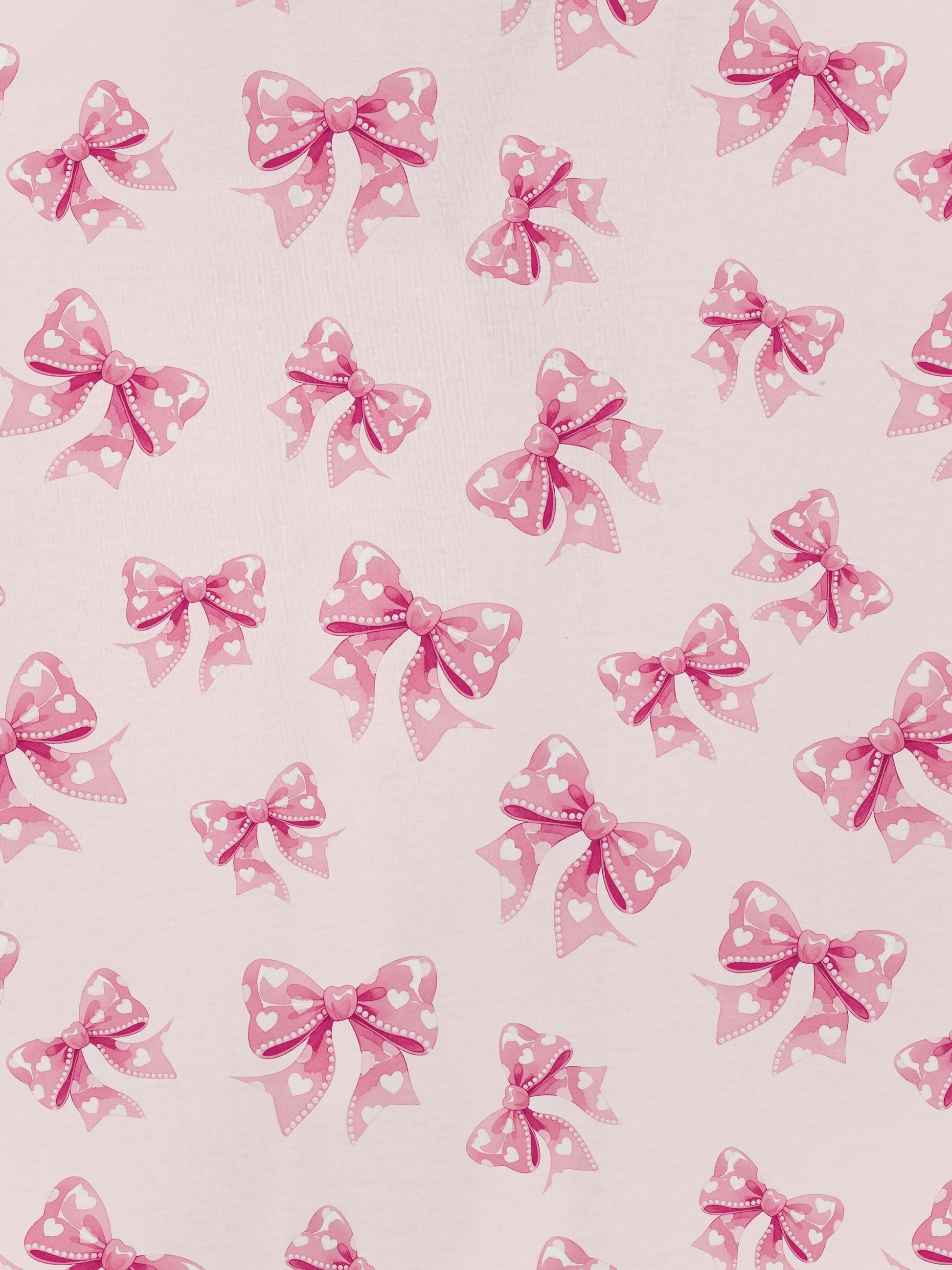 Pastel pink short-sleeve pajama set with heart-dotted bow print — button-up top and elastic waist shorts with pink piping