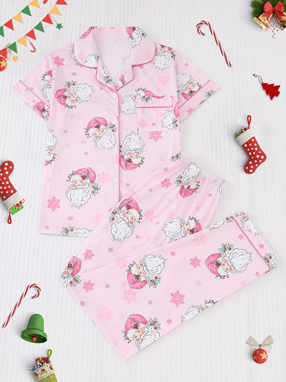 Pink satin-look pajama set with watercolor Santa print and snowflakes, short-sleeve button top with piped pocket and elastic waist full-length pants — 95% Polyester/5% Elastane, silky and breathable