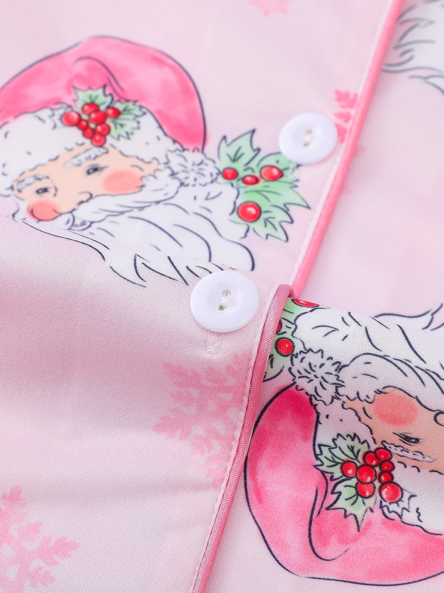 Pink satin-look pajama set with watercolor Santa print and snowflakes, short-sleeve button top with piped pocket and elastic waist full-length pants — 95% Polyester/5% Elastane, silky and breathable
