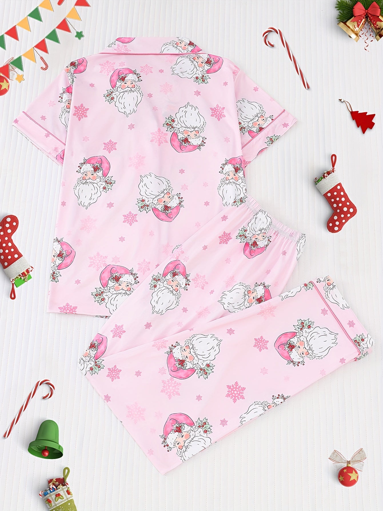 Pink satin-look pajama set with watercolor Santa print and snowflakes, short-sleeve button top with piped pocket and elastic waist full-length pants — 95% Polyester/5% Elastane, silky and breathable