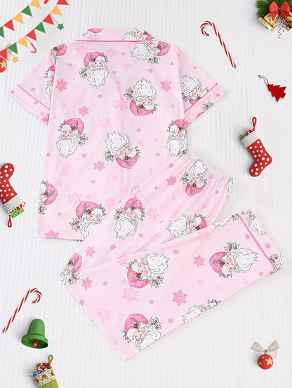 Pink satin-look pajama set with watercolor Santa print and snowflakes, short-sleeve button top with piped pocket and elastic waist full-length pants — 95% Polyester/5% Elastane, silky and breathable