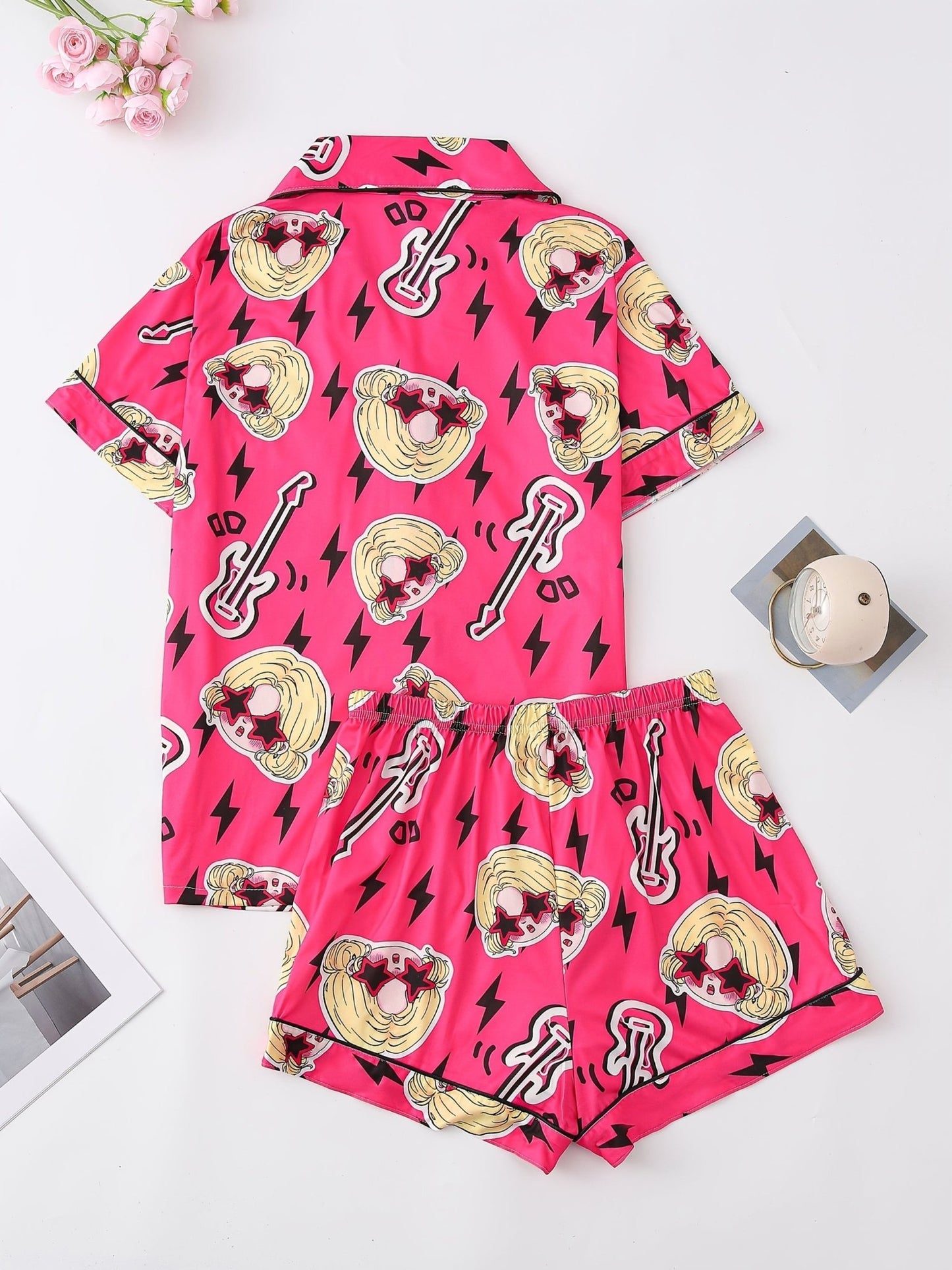 Bright pop-pink satin-look short-sleeve pajama set with guitar and star-sunglasses print, piped trim, chest pocket and elastic waist shorts in 95% Polyester 5% Elastane — silky stretch travel-ready loungewear