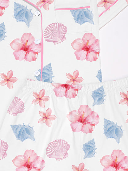 White modal pajama set with pastel seashell and hibiscus print — short sleeve button top and elastic waist shorts with piping