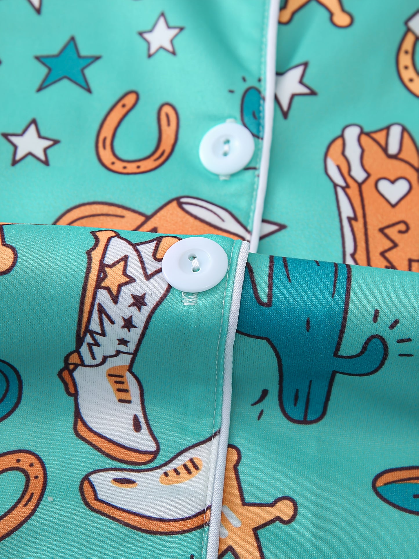 Turquoise satin-look pajama set with western boot and horseshoe print — short-sleeve button-up top with chest pocket and elastic waist shorts, 95% Polyester/5% Elastane