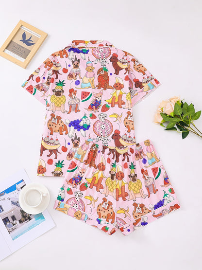 Pink satin-look short-sleeve pajama set with colorful puppy and fruit print, piped trim, chest pocket and elastic waist shorts in 95% Polyester 5% Elastane — silky stretch travel-ready loungewear