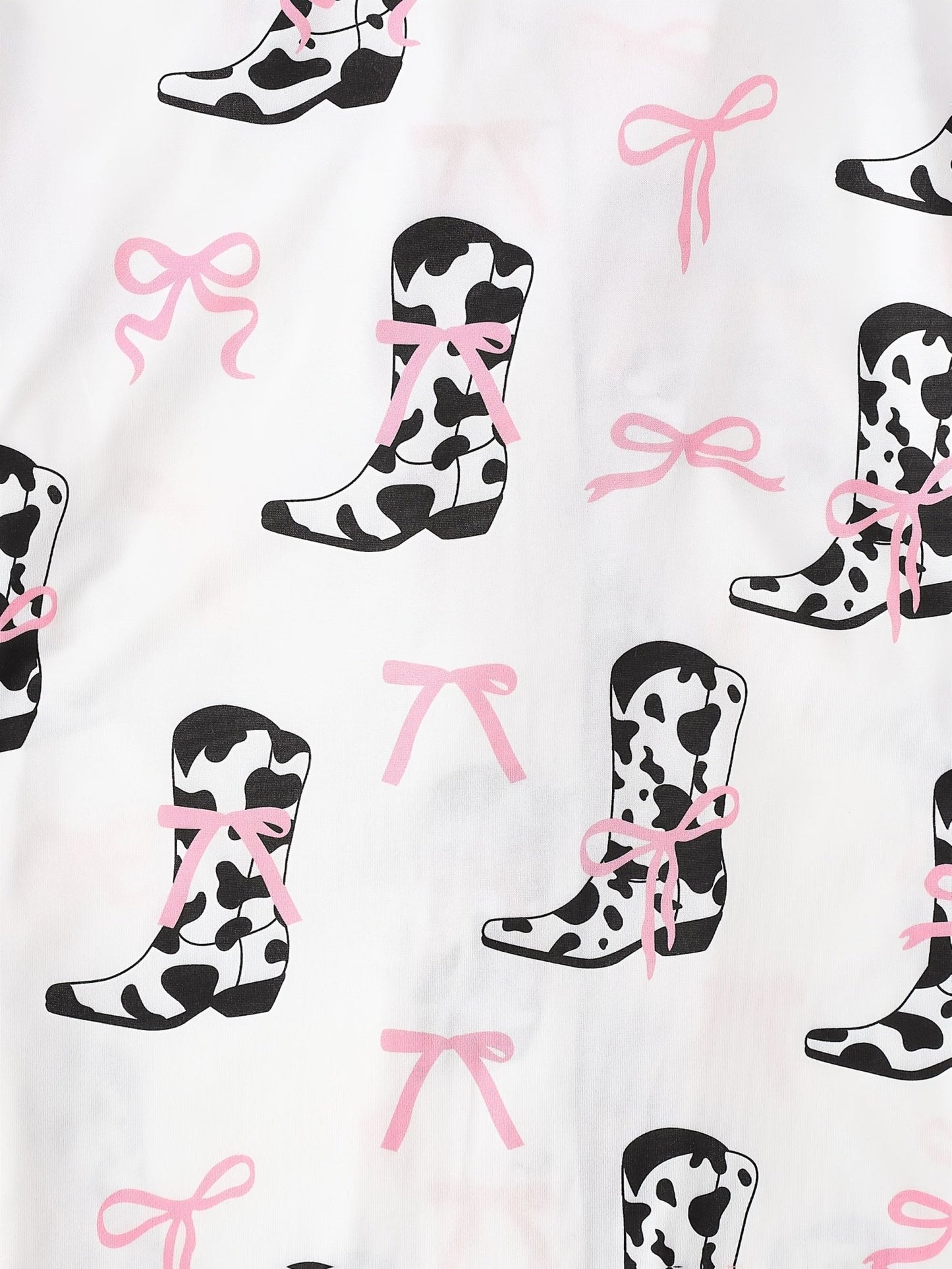 White cow-print short-sleeve pajama set with pink bow accents in silky 95% Polyester 5% Elastane, featuring chest pocket and elastic waist shorts