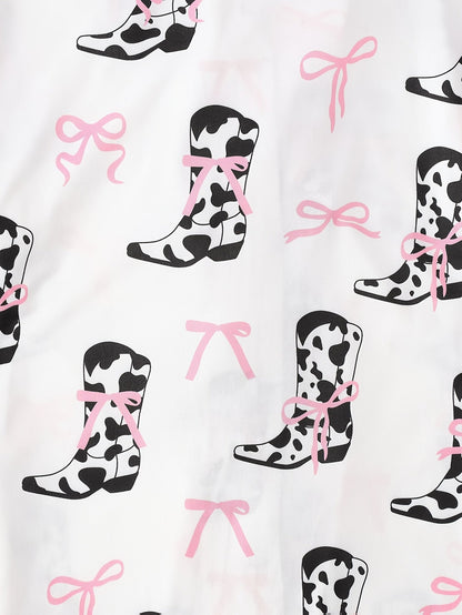 White cow-print short-sleeve pajama set with pink bow accents in silky 95% Polyester 5% Elastane, featuring chest pocket and elastic waist shorts